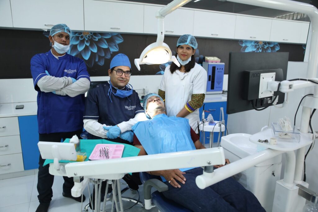 Dr rajesh gupta best dentist in jaipur at Youdent hospital treating to patient with his team